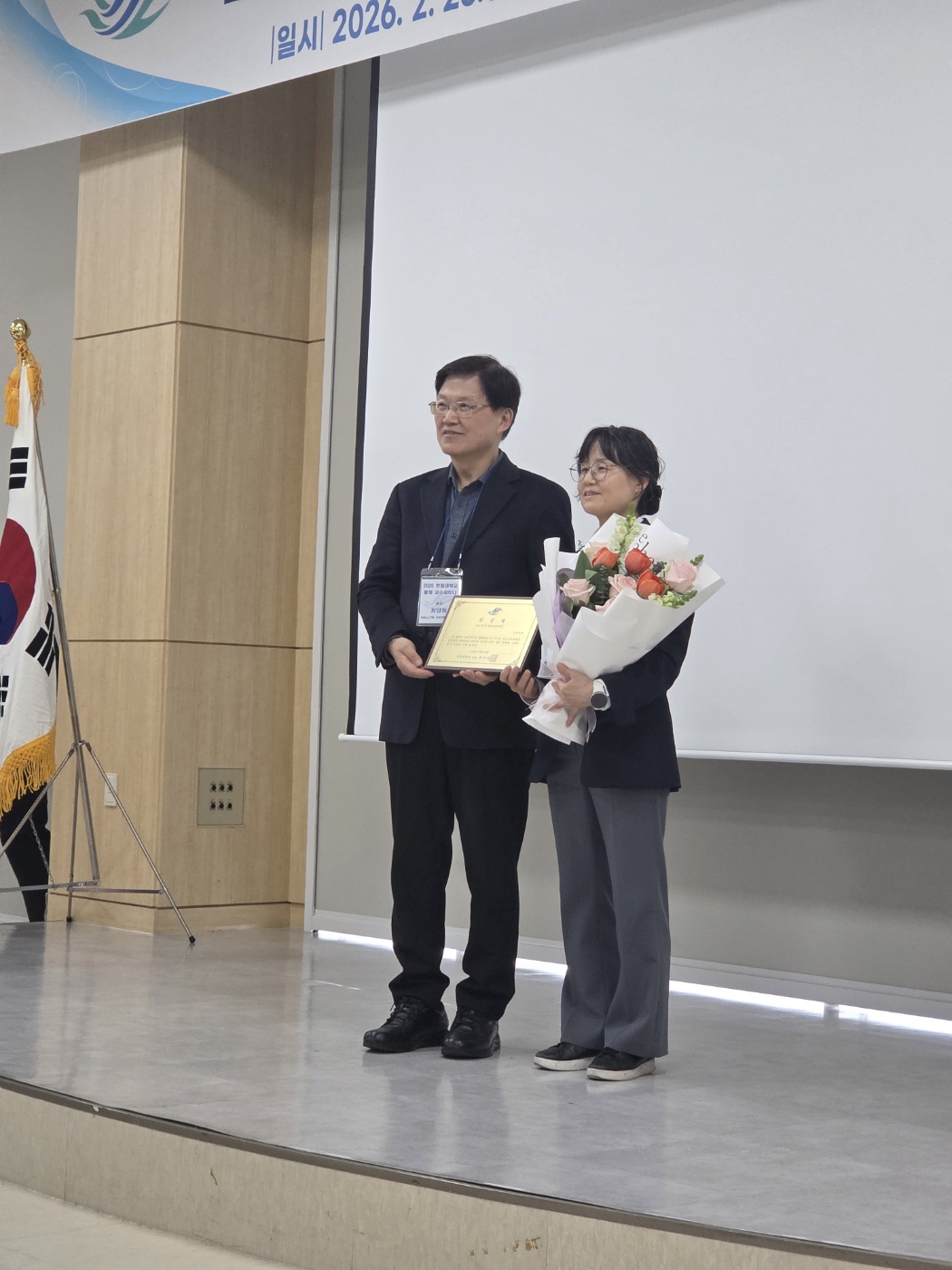 2025학년도 HiFIVE 전공교육과정 우수 운영학과 선정 시상식이 진행 중이다. 시상자와 간호대학 학장님이 꽃다발과 수상패를 들고 서있다.